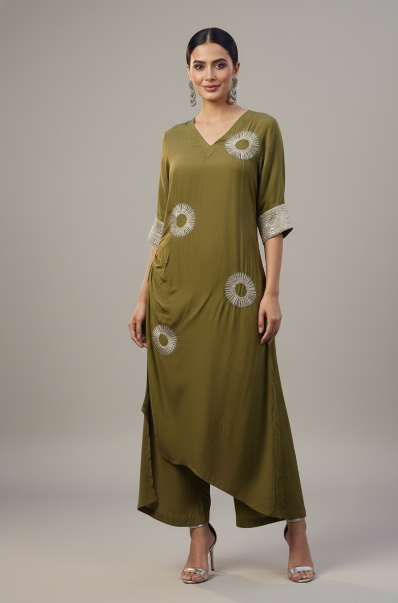 Woman wearing a green dress with floral embroidery on a neutral background
