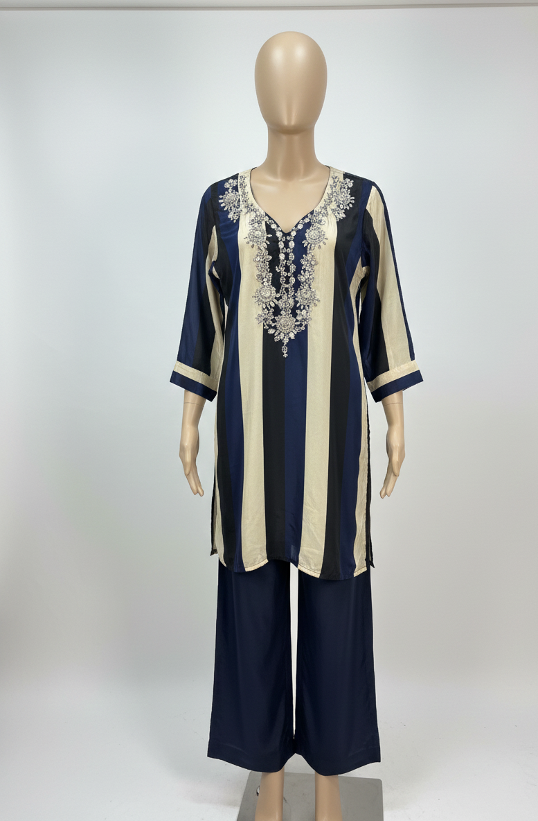 Mannequin wearing a navy and beige outfit with intricate detailing on a white background