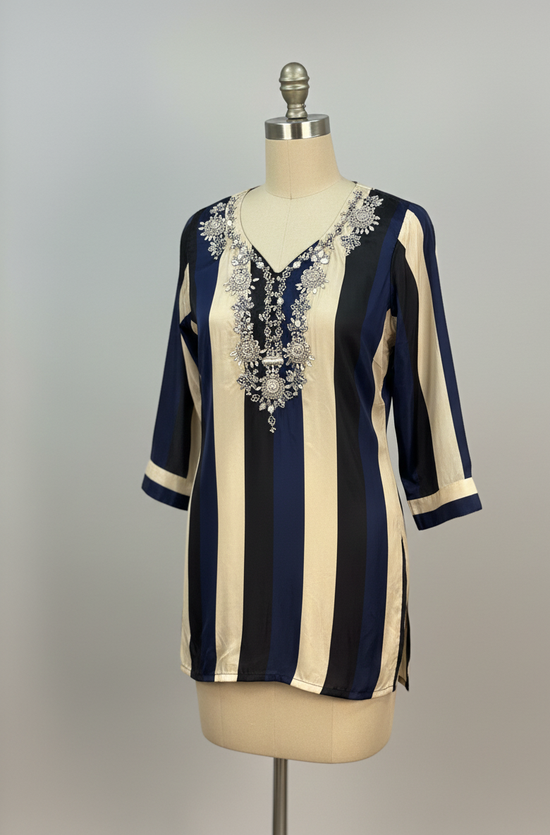 Navy and beige striped top with intricate silver embroidery on a mannequin against a gray background