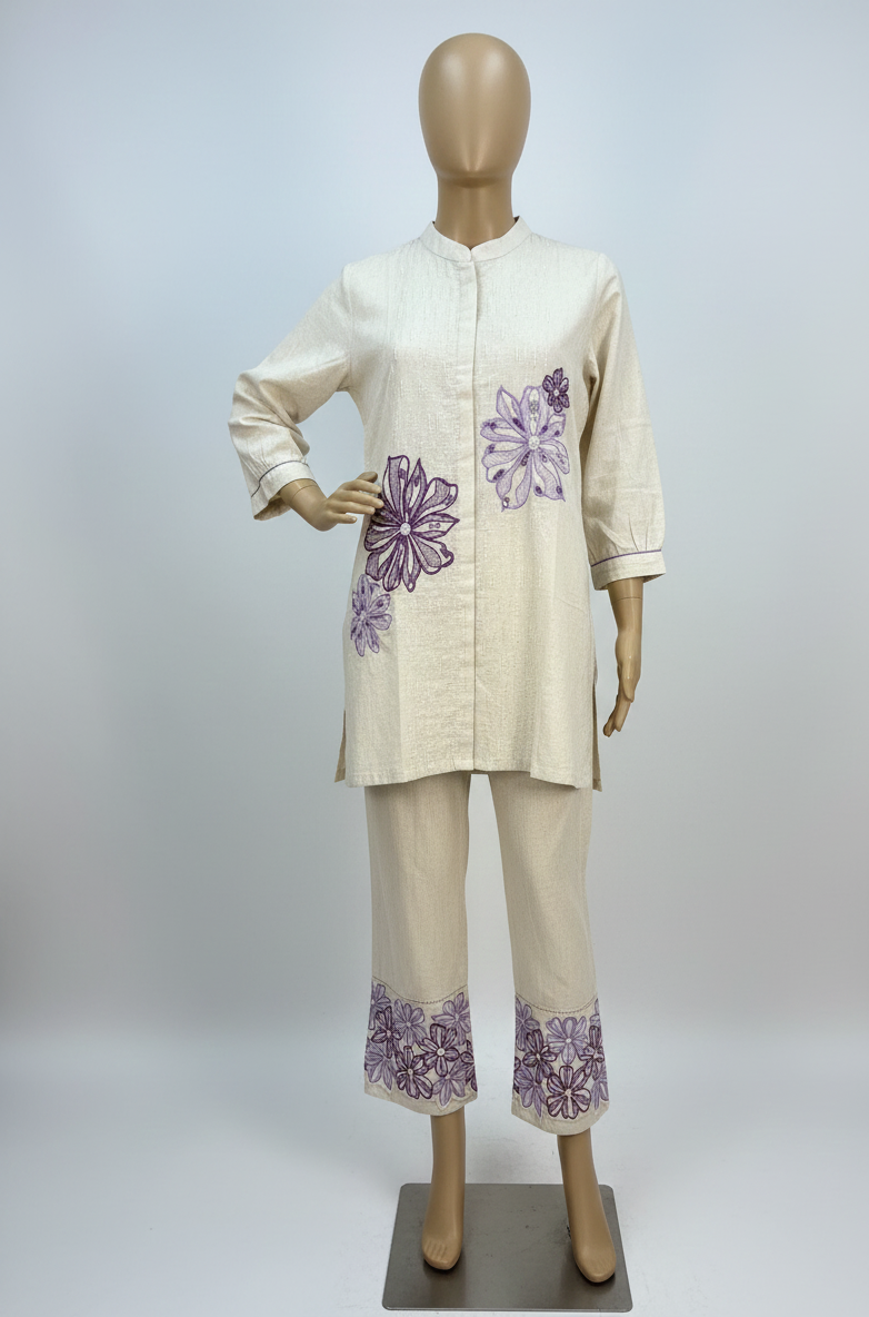 Mannequin wearing a cream outfit with purple floral patterns on a white background