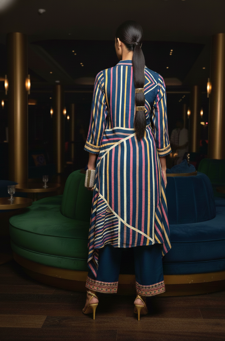 Woman in a colorful striped outfit standing in a modern interior setting.