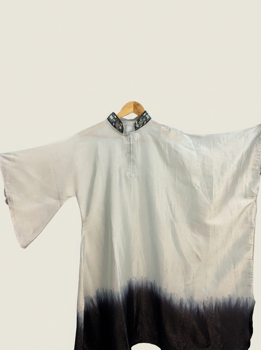 White and black gradient dress on a hanger against a white background