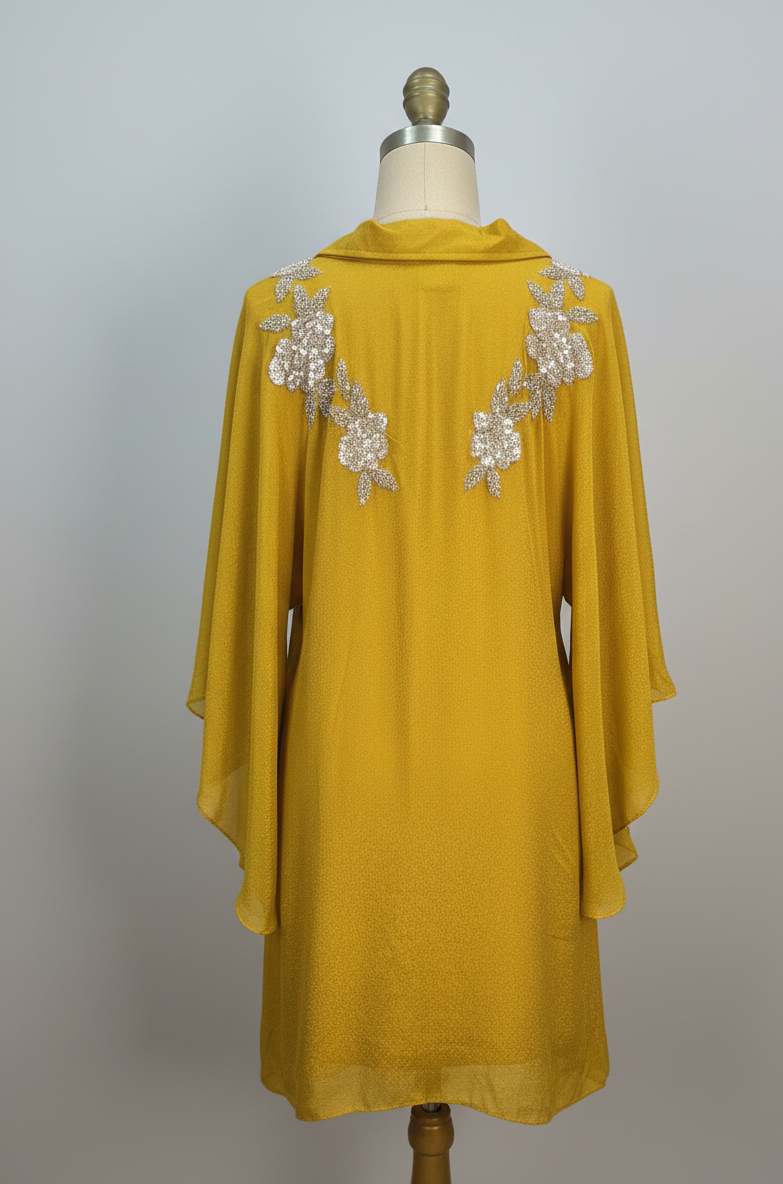Yellow dress with floral embellishments on a mannequin against a gray background