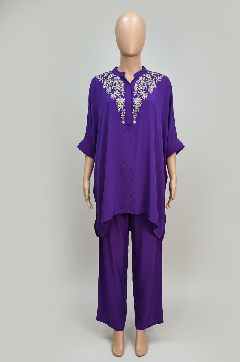 Purple outfit with floral embroidery on a mannequin against a gray background