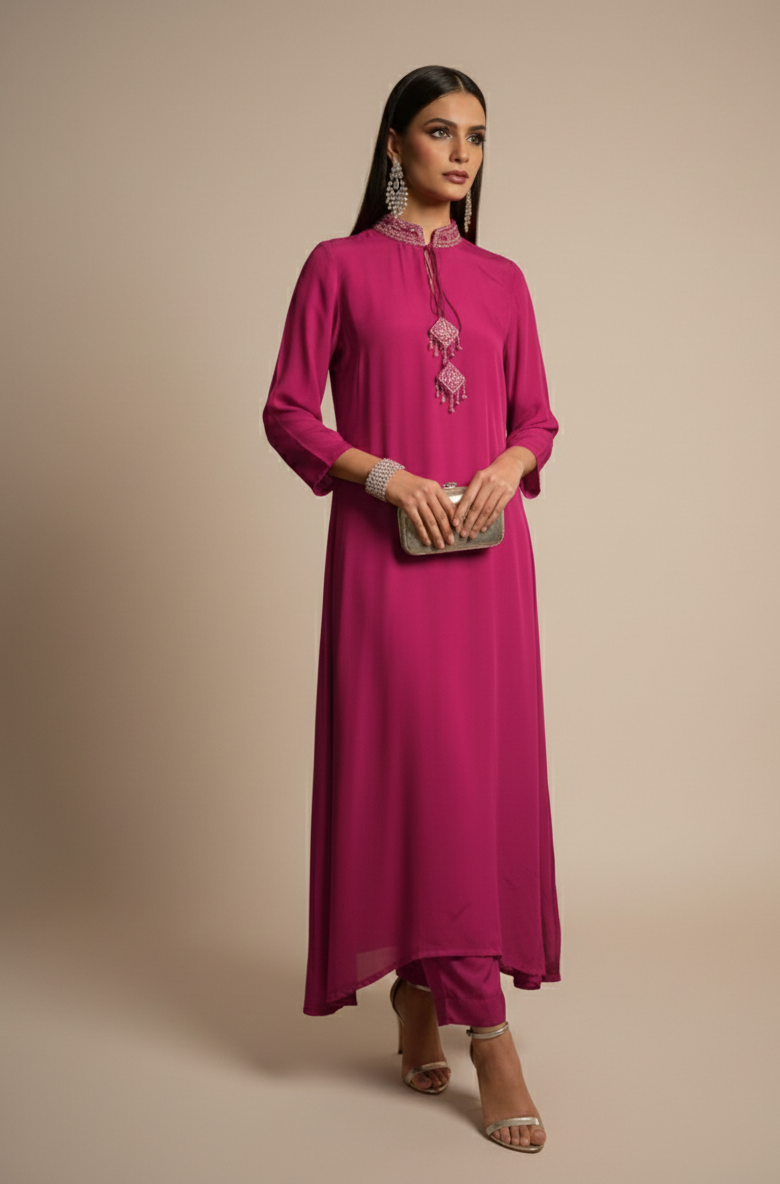 Woman wearing a pink traditional outfit with embroidery on a beige background