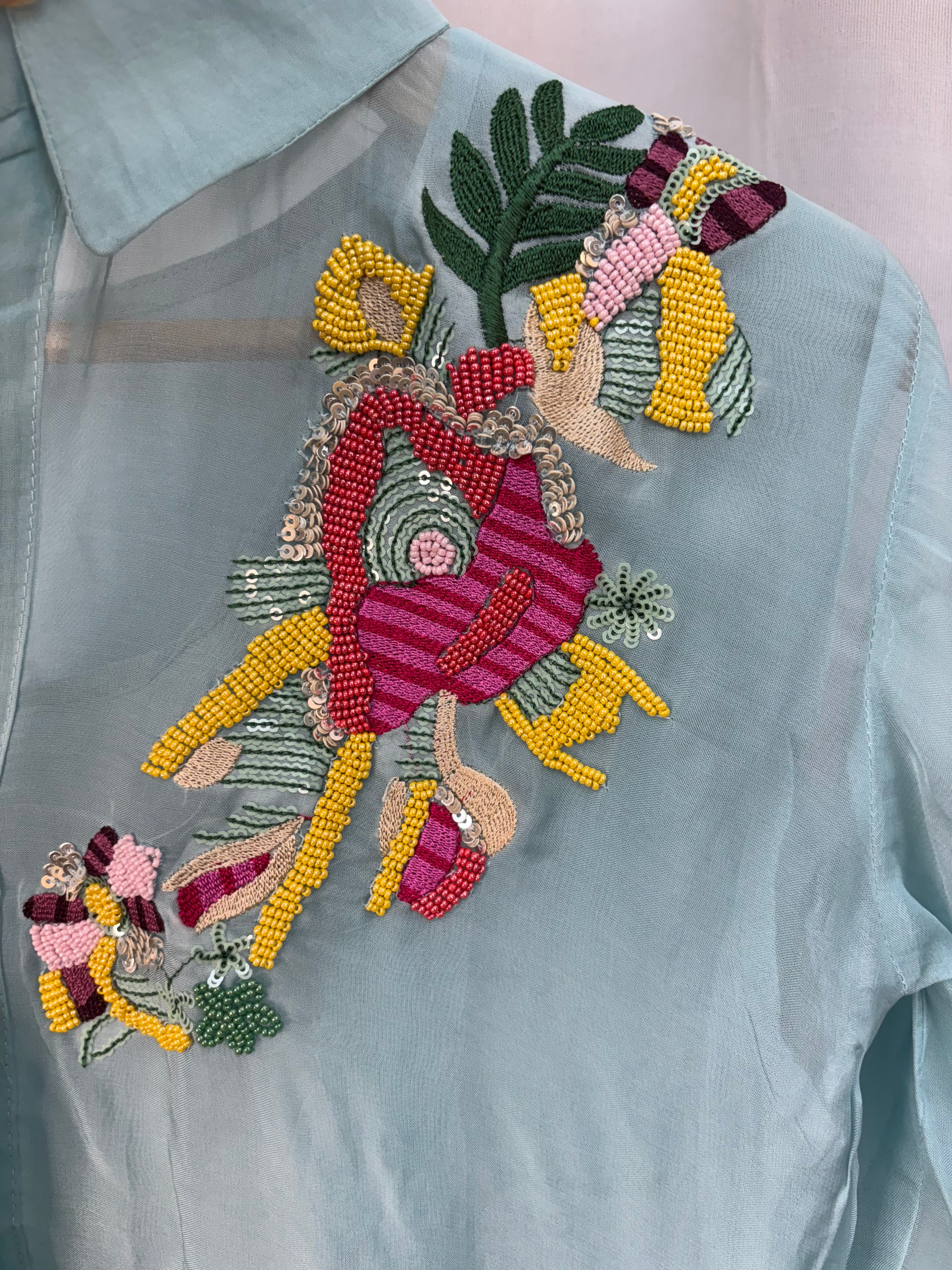 Decorative embroidered patch on a light blue fabric background