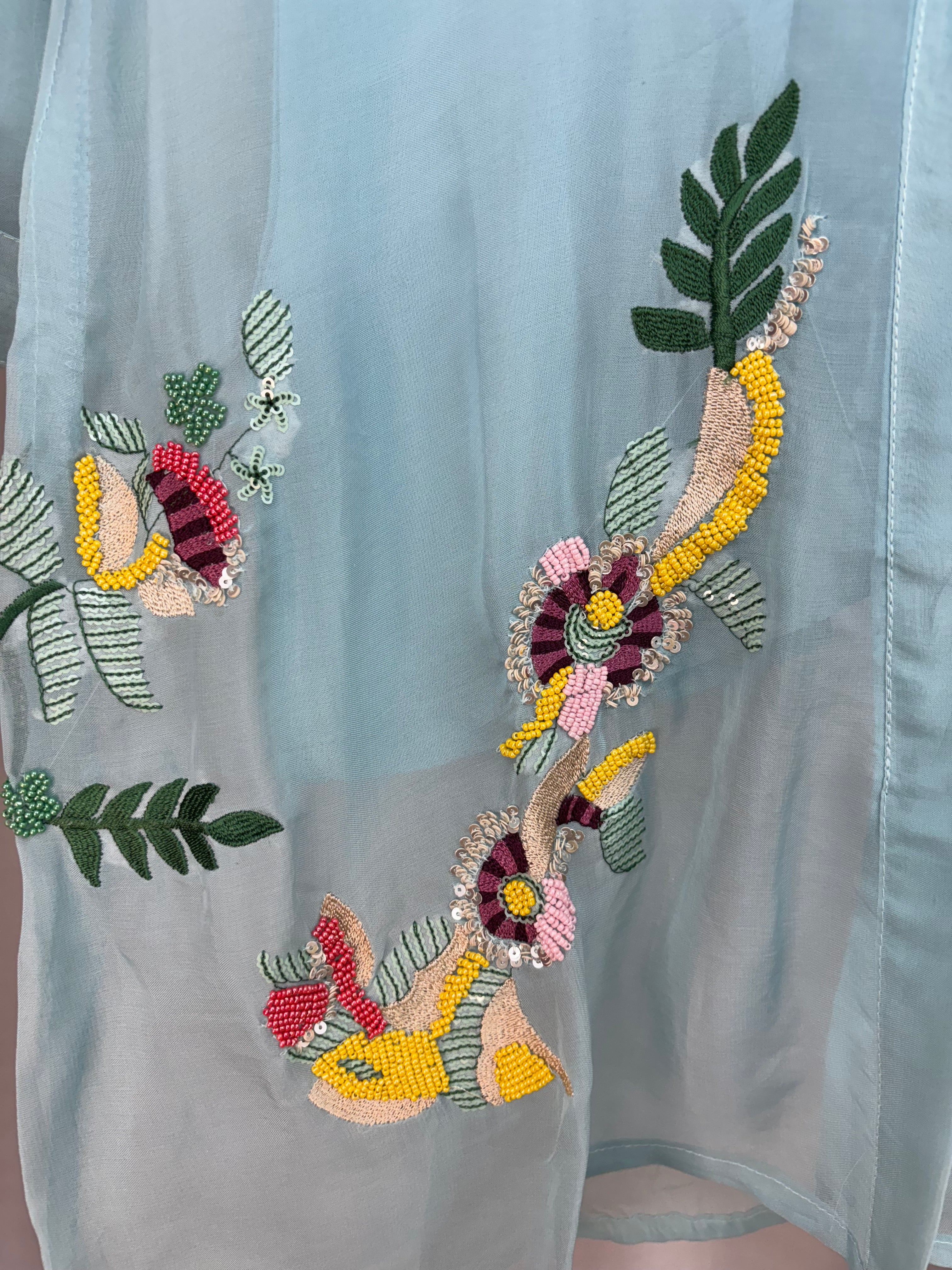 Decorative floral and leaf pattern on a light blue fabric background