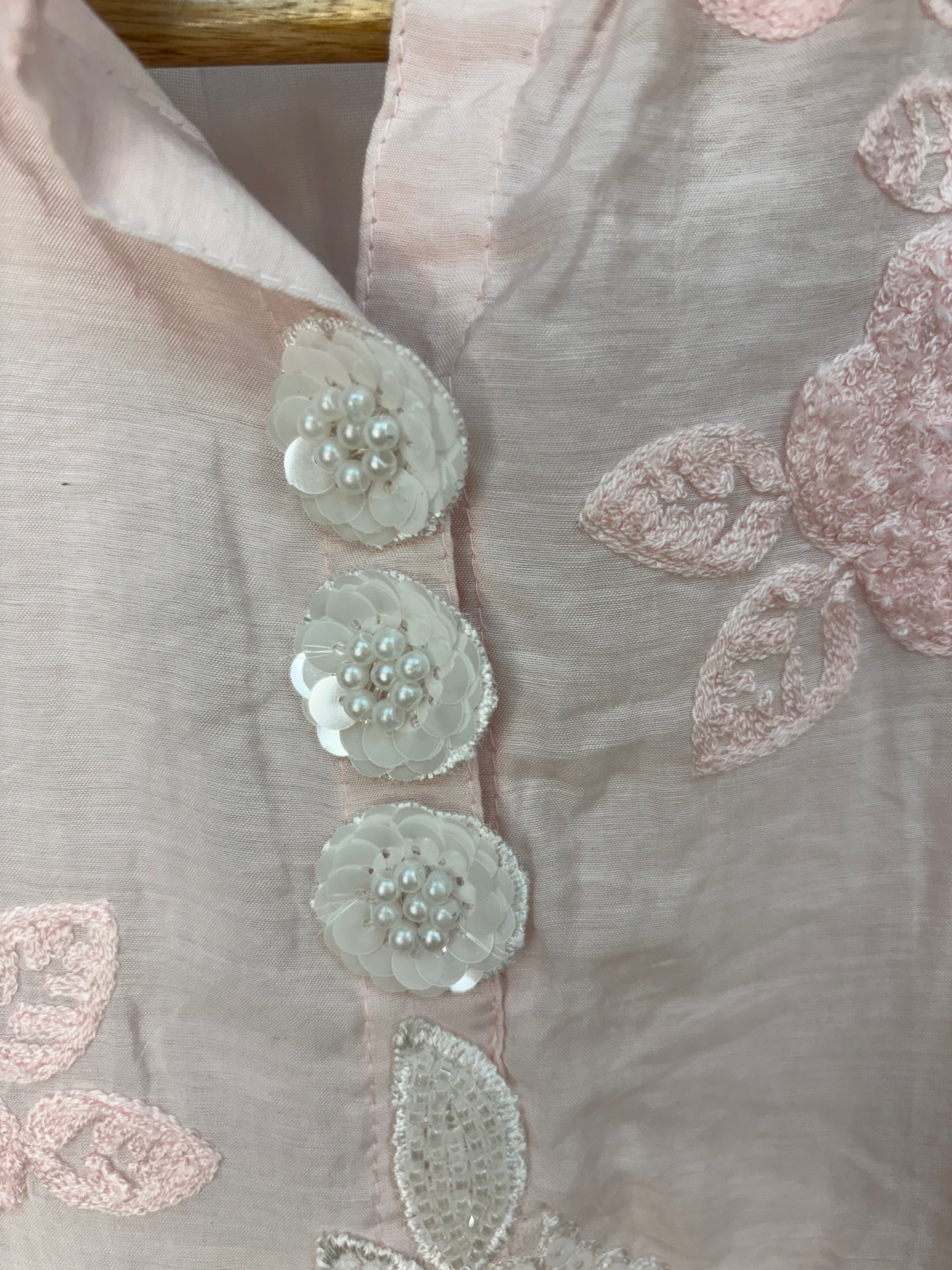 Close-up of embroidered fabric with floral patterns on a light background