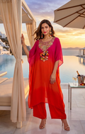 Woman in a red outfit standing by a poolside with a scenic background