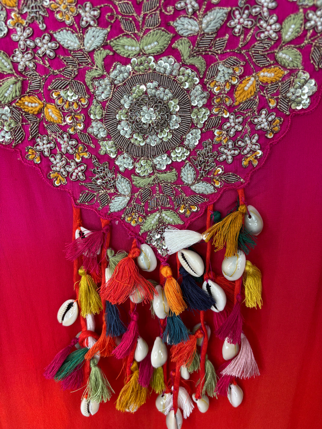 Decorative fabric with intricate patterns and tassels on a red background