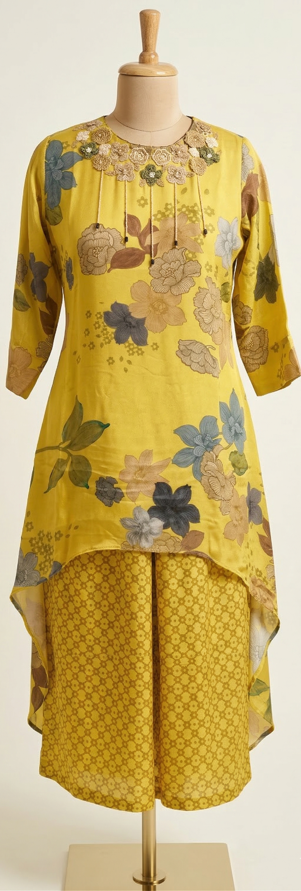 Yellow floral dress on a mannequin against a white background