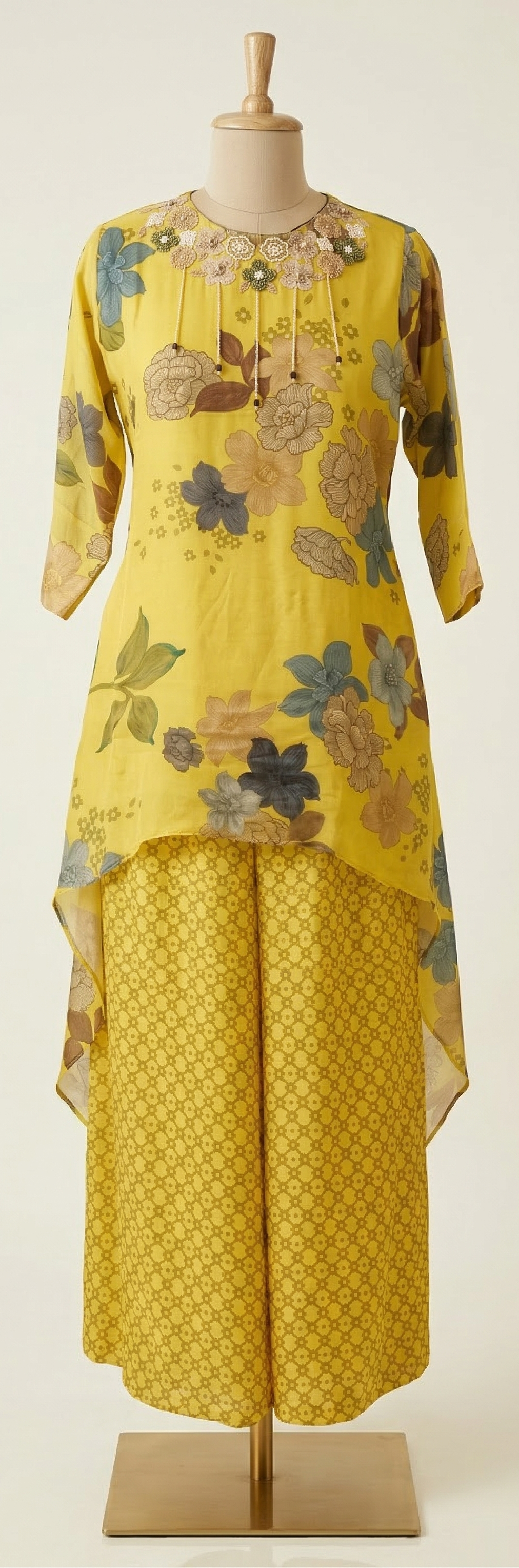 Yellow floral dress on a mannequin against a white background