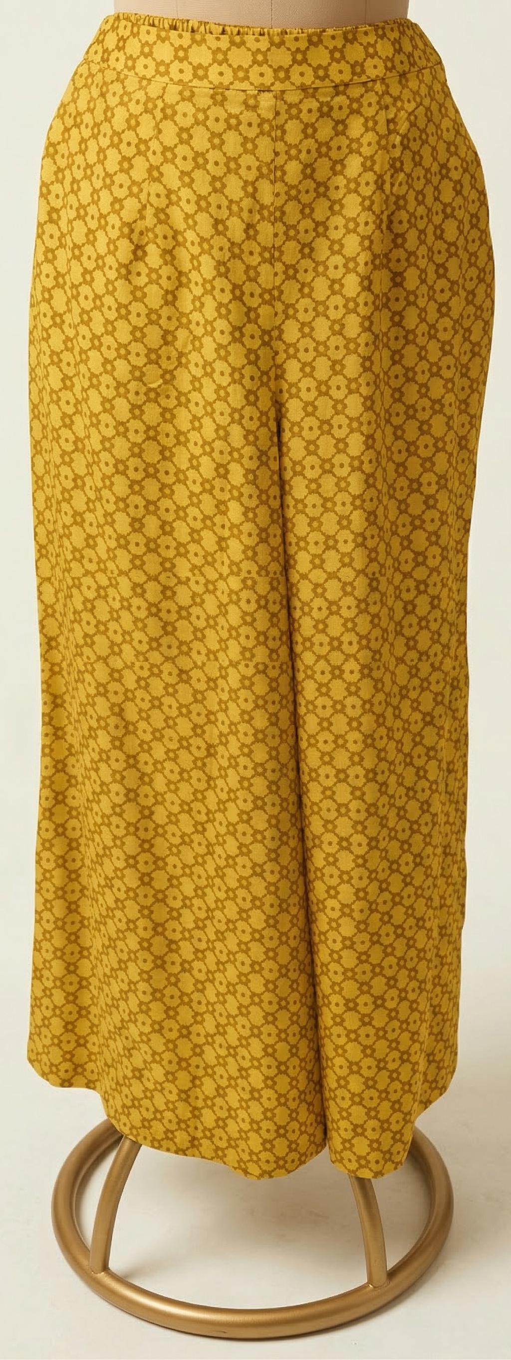 Yellow patterned skirt on a mannequin against a white background