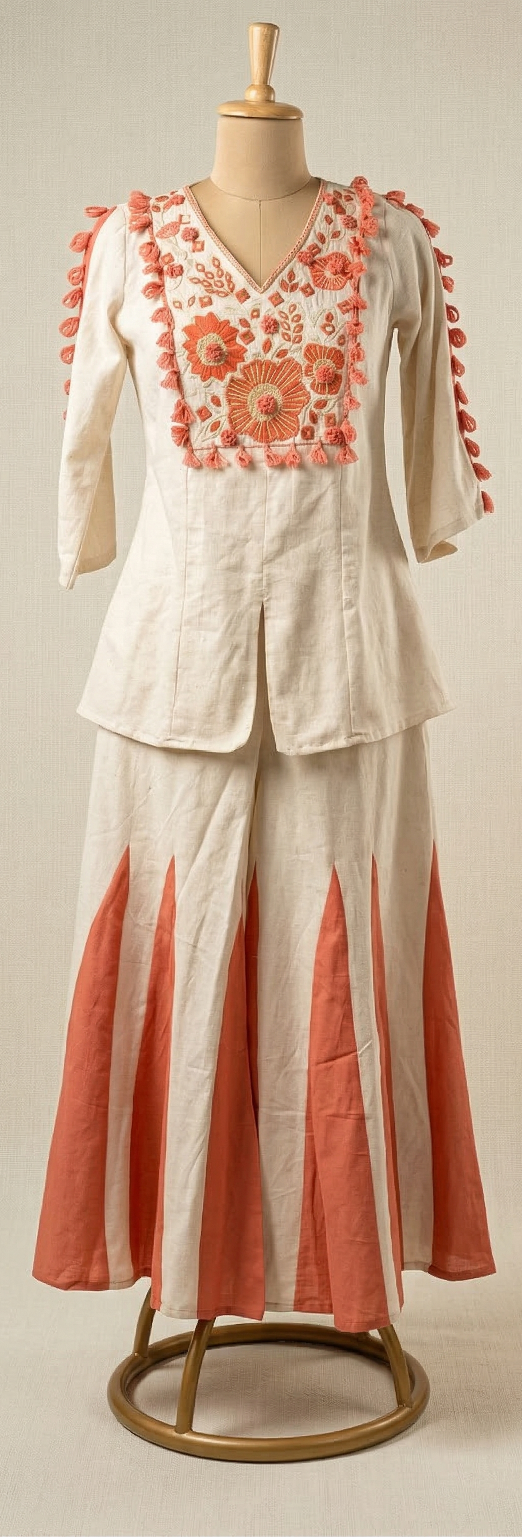 Two-piece outfit with floral embroidery on a mannequin against a plain background