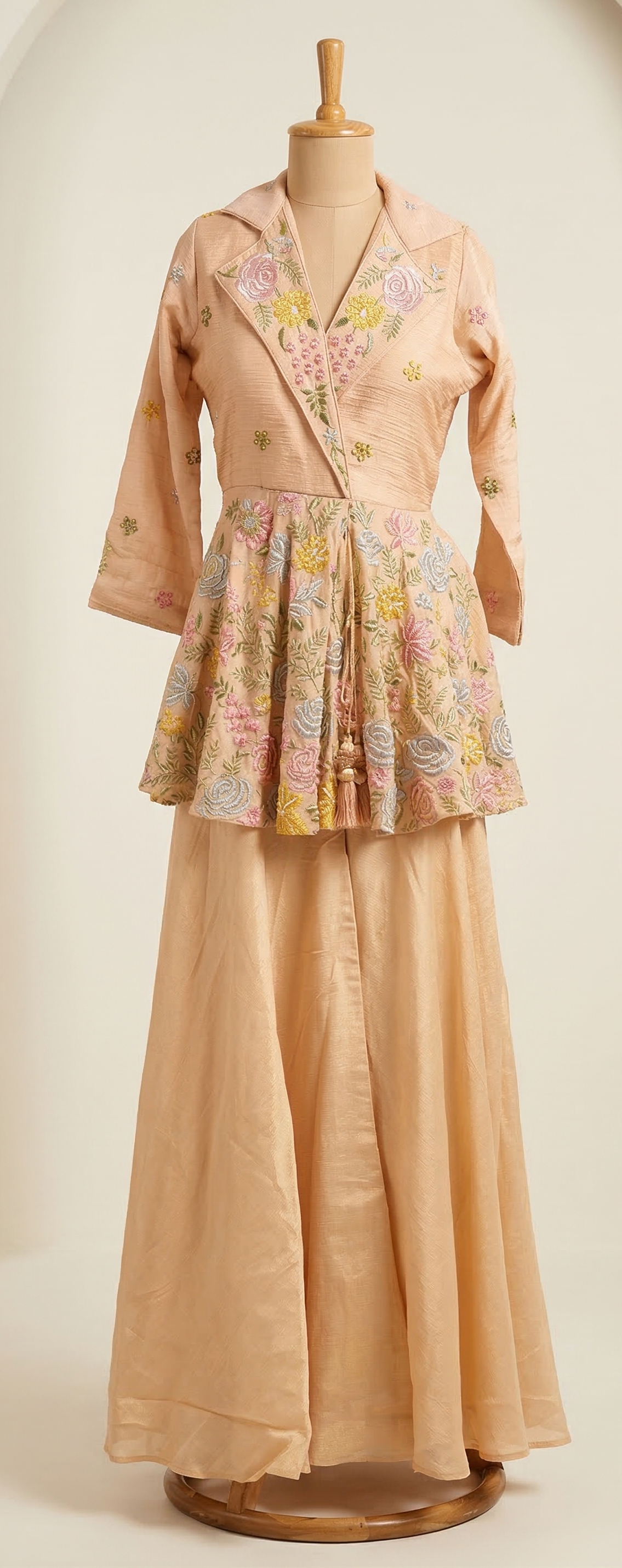 Mannequin wearing a vintage outfit with a floral top and beige skirt on a plain background
